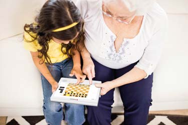 Oma und Enkelin spielen Spiele auf dem SeniorCarePro Gerät